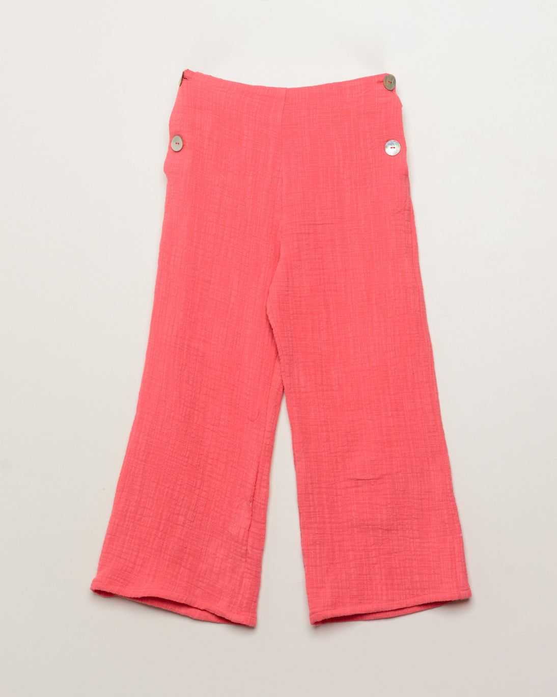 Pink pants with button details on a light gray background