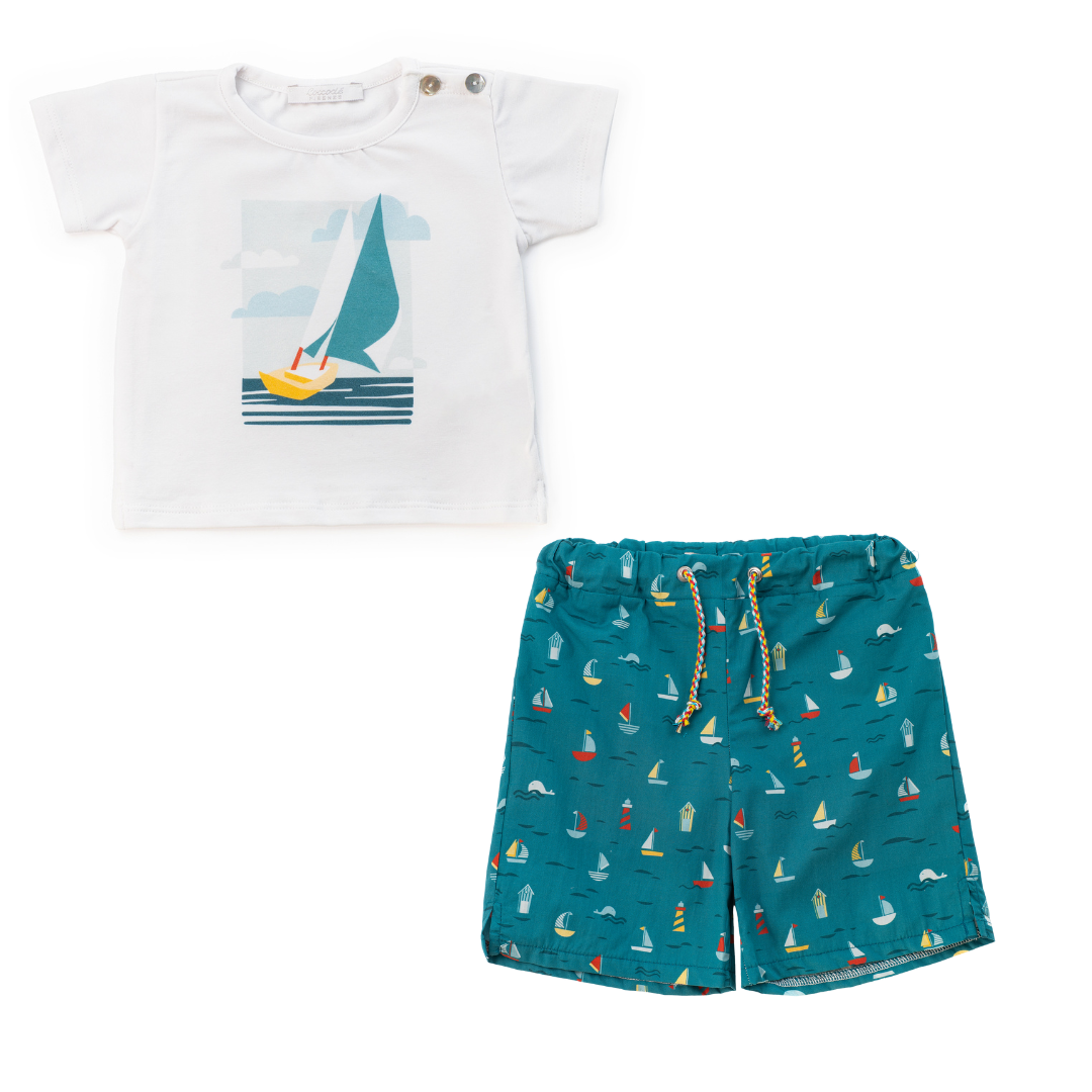 Children's t-shirt with sailboat design and teal shorts with nautical pattern on a white background