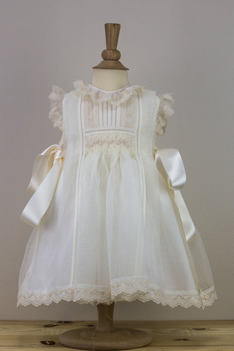 White lace dress on a mannequin against a plain background