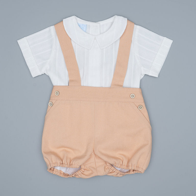 Baby romper with beige overalls and white shirt on a gray background